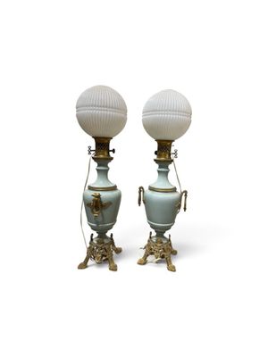 une paire de lampes blanches et dorées, chacune dotée d'un abat-jour en verre