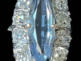 une image représentant une bague en diamant bleue et blanche sur fond noir