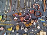many different types of necklaces and bracelets laid out on a table