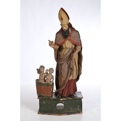une statue représentant un homme coiffé d'un chapeau et vêtu d'une robe, debout à côté d'une plante en pot