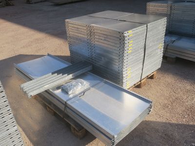 plusieurs piles de tôles d'acier empilées les unes sur les autres sur une palette