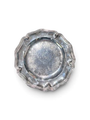 une plaque d'argent sur une surface blanche avec un fond blanc