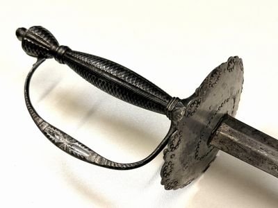 gros plan d'une épée sur une surface blanche