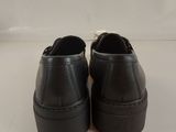 black leather shoes with black soles on a white surface