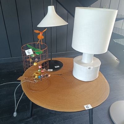 une table sur laquelle se trouvent une lampe et une cage à oiseaux