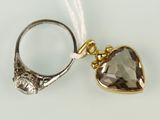 une image représentant une bague avec une pierre en forme de cœur, suspendue à un fil