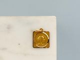 une médaille d'or posée sur un bloc de marbre blanc