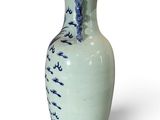 a blue and white vase sitting on a white surface