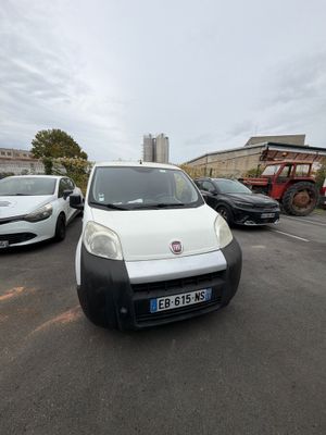 une petite camionnette blanche garée dans un parking