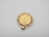 a gold coin pendant on a white surface