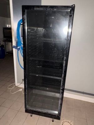un réfrigérateur noir avec une porte vitrée dans une pièce