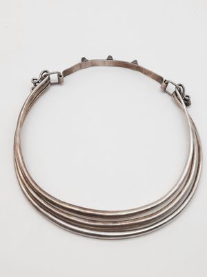 un gros plan d'un collier en argent sur fond blanc