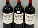 three bottles of red wine are lined up on a white surface