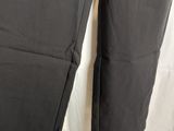a pair of black pants hanging from a hanger on a white curtain