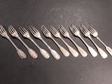six forks are arranged in a row on a black surface