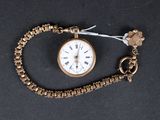 une montre en or avec une chaîne, posée sur un fond noir