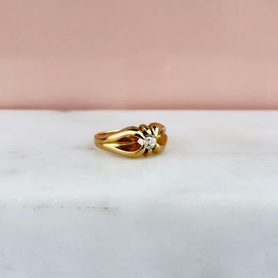 an image of a gold ring sitting on a marble surface