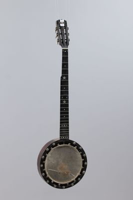 a close up of a banjo hanging from a string on a wall