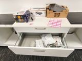 a white desk with a drawer full of office supplies