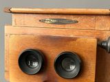 an old wooden camera with two lenses on top of it