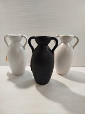 trois vases blancs et noirs posés sur une surface blanche