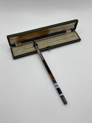 a close up of a pen and a book on a white surface