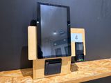 une tablette et un téléphone posés sur une étagère en bois