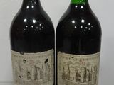 two bottles of wine sitting on top of a table next to each other