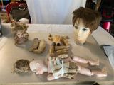 une table sur laquelle sont posées plusieurs têtes de poupées et d'autres objets