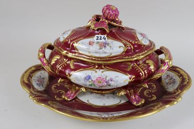 a red and gold plate with a bowl and saucer on it