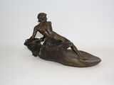 bronze statue of a woman sitting on a cow on a white surface