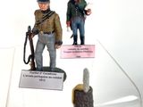three figurines of soldiers on display in a glass case