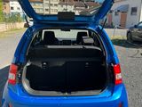 the back end of a blue car with its trunk open