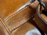 a close up of a brown leather bag with a metal buckle