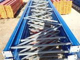 a man standing in front of a pile of steel beams