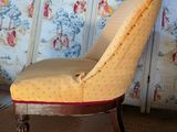a chair that is sitting in front of a wallpapered wall
