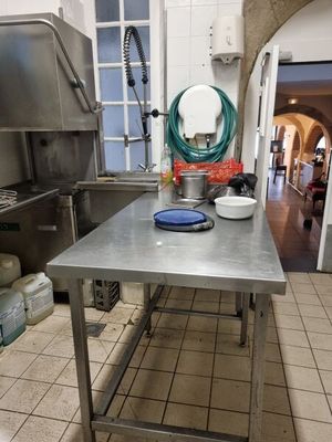 a kitchen with a stainless steel table in the middle of the room