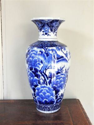 un vase bleu et blanc posé sur une table en bois