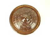 a close up of a brown bowl on a white surface