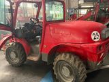 a red tractor that is parked in a garage