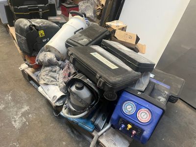 une pile de bagages posée sur une palette dans un garage