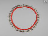 un collier de perles rouges et dorées orné de clochettes