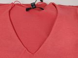 a close up of a red v - neck sweater hanging on a hanger
