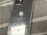 an iphone that is sitting on a bed next to a cell phone