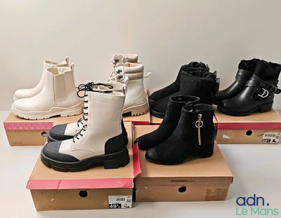 several pairs of black and white boots are on display in a box
