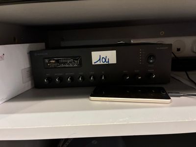 un téléphone portable posé sur une étagère, à côté d'une radio