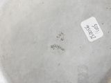 an image of a silver plate with a tag on it