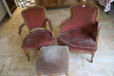deux chaises rouges et un petit pouf dans une pièce
