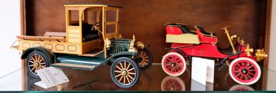 deux voitures anciennes exposées dans une vitrine