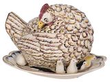 une poule posée sur une assiette sur laquelle se trouvent des œufs